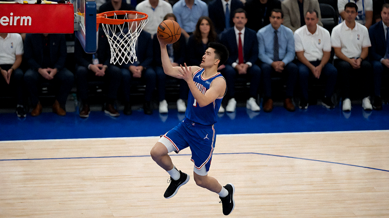 NBA常规赛比赛画面，球员在篮下完成上篮动作的篮球资讯配图